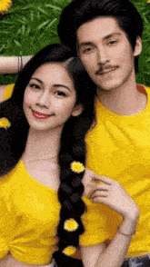 a man and a woman are posing for a picture and the woman has flowers in her braid