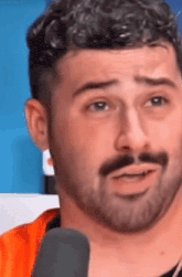 a close up of a man 's face with a microphone in front of him