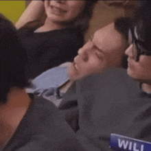 a group of people are sitting on a couch and one of them has a name tag that says will