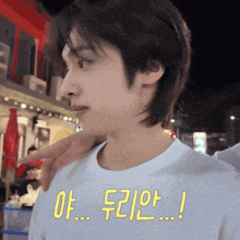 a man wearing a white t-shirt with korean writing on the front