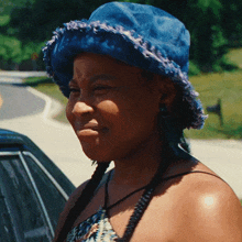 a woman wearing a blue hat is smiling
