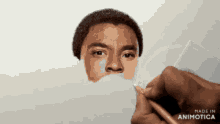 a person is drawing a man 's face with a pencil and the words made in animotica are on the bottom