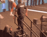 a man standing on a stage with a shirt that says ' coca-cola ' on the back