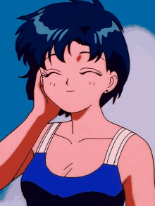 a girl in a blue tank top is smiling and touching her face
