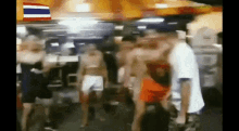 a group of people are dancing in a room with a flag in the background