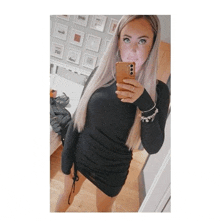a woman in a black dress takes a selfie