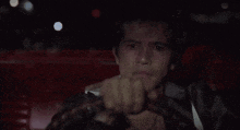a man is crying while driving a red car at night