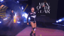 men of the year is written on a screen behind the wrestler