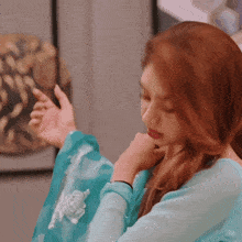 a woman wearing a blue top with a white embroidery on the sleeves