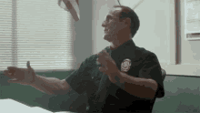 a police officer is sitting at a desk in front of a window