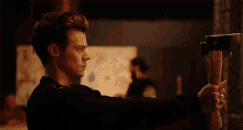 a man in a black shirt is holding a large axe in his right hand
