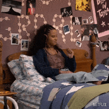 a girl is laying on a bed with a netflix poster on the wall