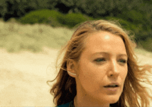 a close up of a woman 's face with a blue shirt on