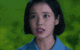 a close up of a woman 's face with a blue shirt on