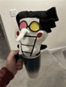 a person is holding a cup of coffee with a stuffed animal in it .