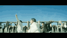 a group of people are dancing in front of a band and a bridge