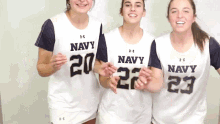 three women wearing under armour navy jerseys stand together