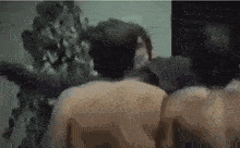 a group of naked men standing next to each other in a room .