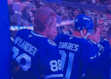 a group of hockey players are standing in a stadium and one of them is wearing a number 91 jersey