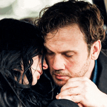 a man and a woman are hugging each other