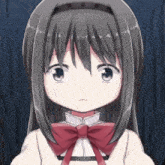 a close up of a girl with a red bow on her neck