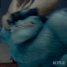 a close up of a blue monster with horns and a netflix logo