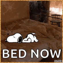 a picture of snoopy laying on a bed with the words bed now