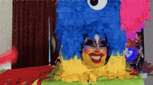 a blue and yellow piñata with a woman 's face in it