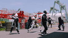 a group of superheros are fighting in a parking lot with a crane in the background
