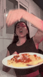 a woman is eating a plate of pasta with sauce