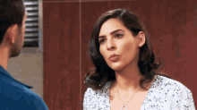 a man and a woman are standing next to each other and the woman is wearing a necklace