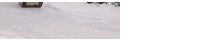 a military tank is driving through the snow .