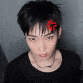 a young man with a red circle on his forehead