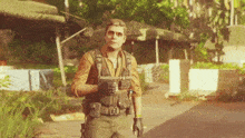 a man wearing sunglasses and a vest with a letter h on it