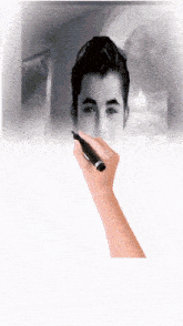 a hand with a marker draws a picture of a boy