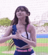 a cheerleader is dancing on a baseball field in front of a crowd .
