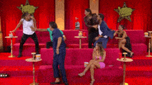 a group of people are sitting on a pink couch in front of a red curtain with a star in the background