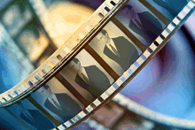 a close up of a film strip showing three men in suits and ties