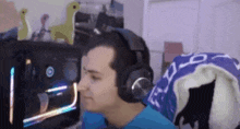 a man wearing headphones is sitting in front of a computer and looking at the screen .