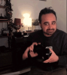 a man with a beard is holding a black object