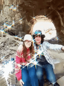 a man and a girl are posing for a picture in front of a cave