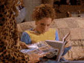 a woman is looking at a book with a picture of a boy on it
