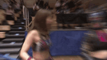 a blurry picture of two women wrestling in a ring