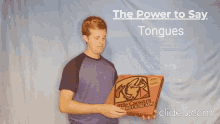 a man is holding a pizza box with the words " the power to say tongues " behind him