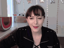 a woman wearing a black jacket that says " dreaming twins "