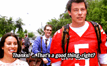 a man in a red jersey with the number 5 on it is talking to a woman