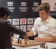 two men are playing chess in front of a norway chess sign