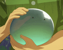 a person in a green shirt is holding a clear ball in their hands