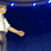 a blurry photo of two people dancing on a stage with blue lights behind them
