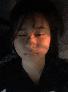 a girl with her eyes closed is laying on a bed
